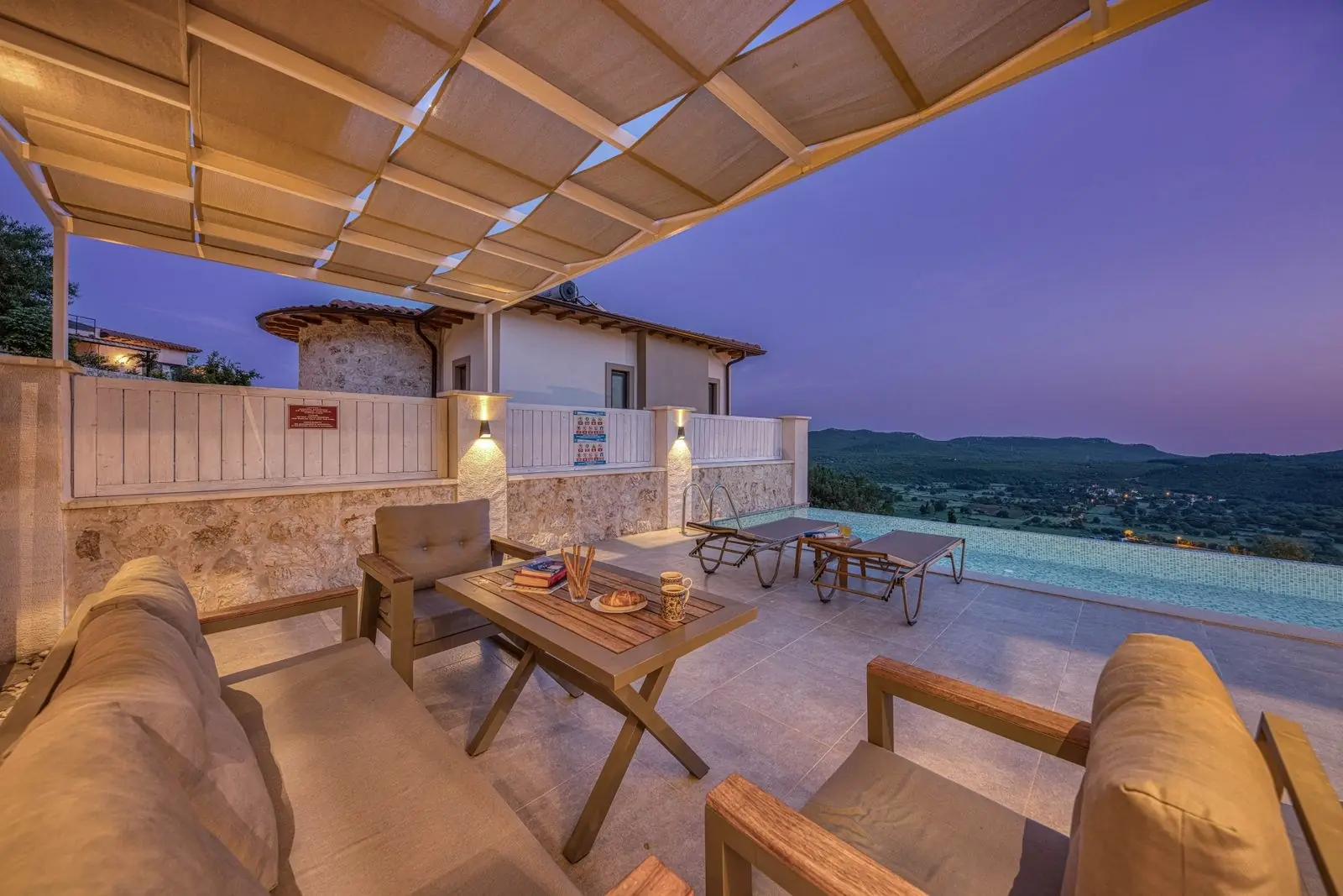 Terraza con pérgola y piscina al anochecer